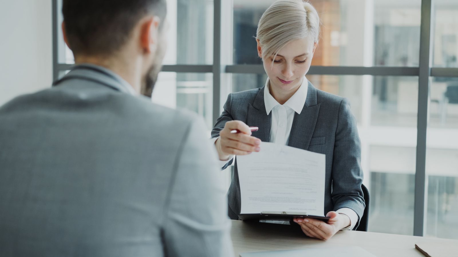 Two business professionals reviewing a contract at an office desk